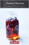 A mason jar mostly filled with pickled cherries, pickling liquid, star anise, and a cinnamon stick.