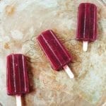 Three red wine popsicles on a silver tray.