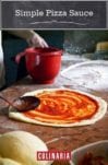 A wooden spoon spreading simple pizza sauce on a round of pizza dough.