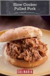 Slow cooker pulled pork piled on a bun on a plate.