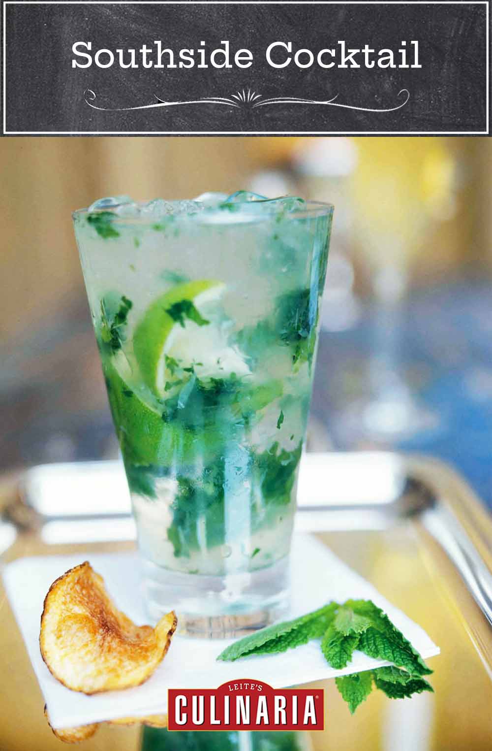 A southside cocktail on a napkin on a silver tray with a potato chip and sprig of mint beside it.