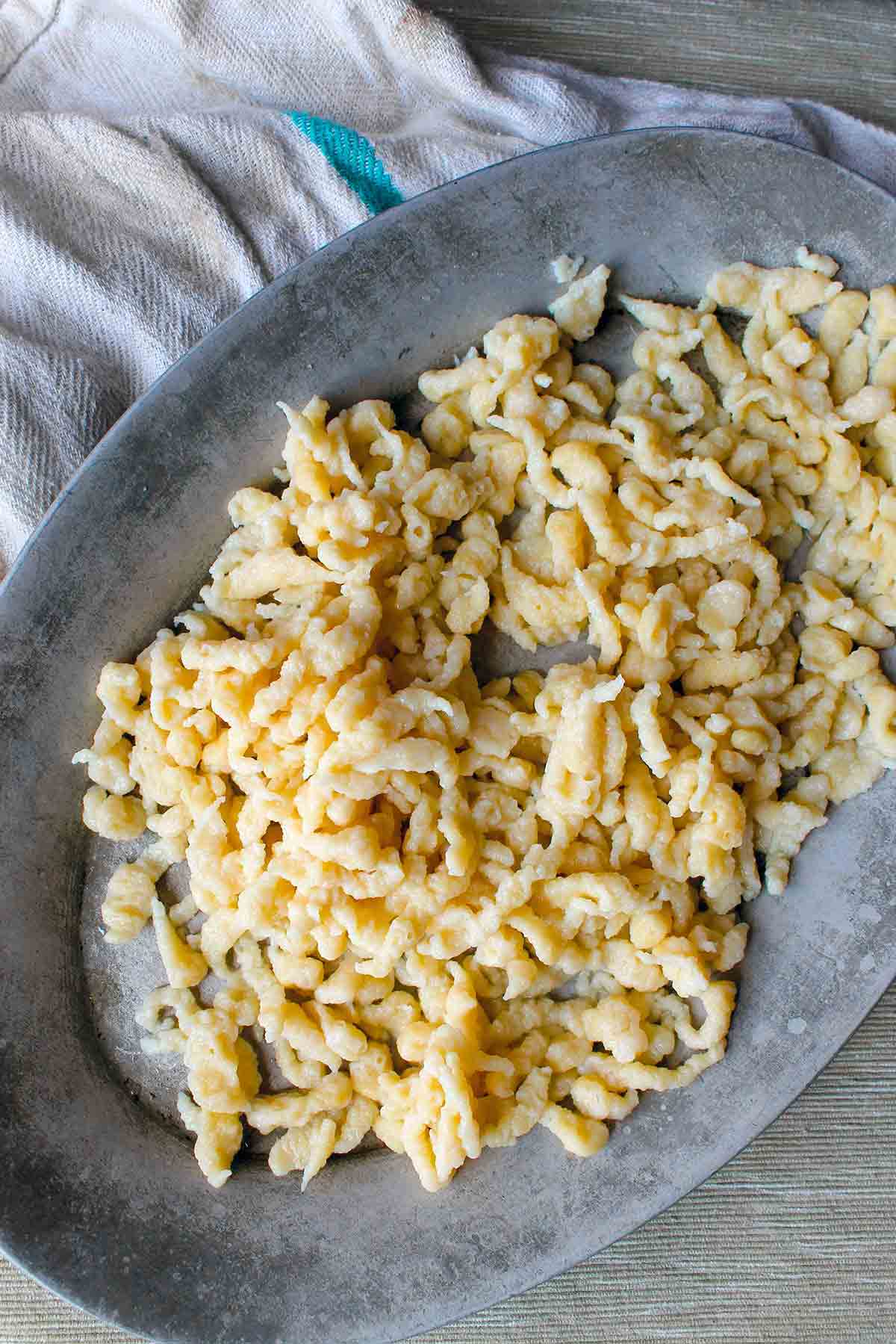 An oval platter filled with homemade spaetzle.