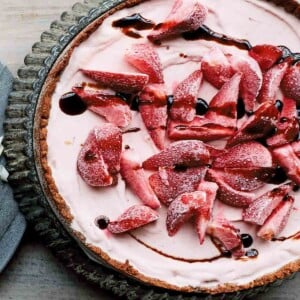 A whole strawberry ice cream pie in a fluted tart pan.