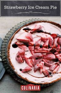 A whole strawberry ice cream pie in a fluted tart pan.