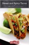 Three sweet and spicy tacos on a white plate with wedges of lime alongside.