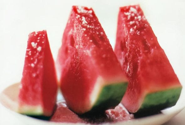 Three slices of watermelon with fleur de sel sprinkled over top.