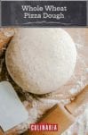 A ball of whole wheat pizza dough on a floured surface