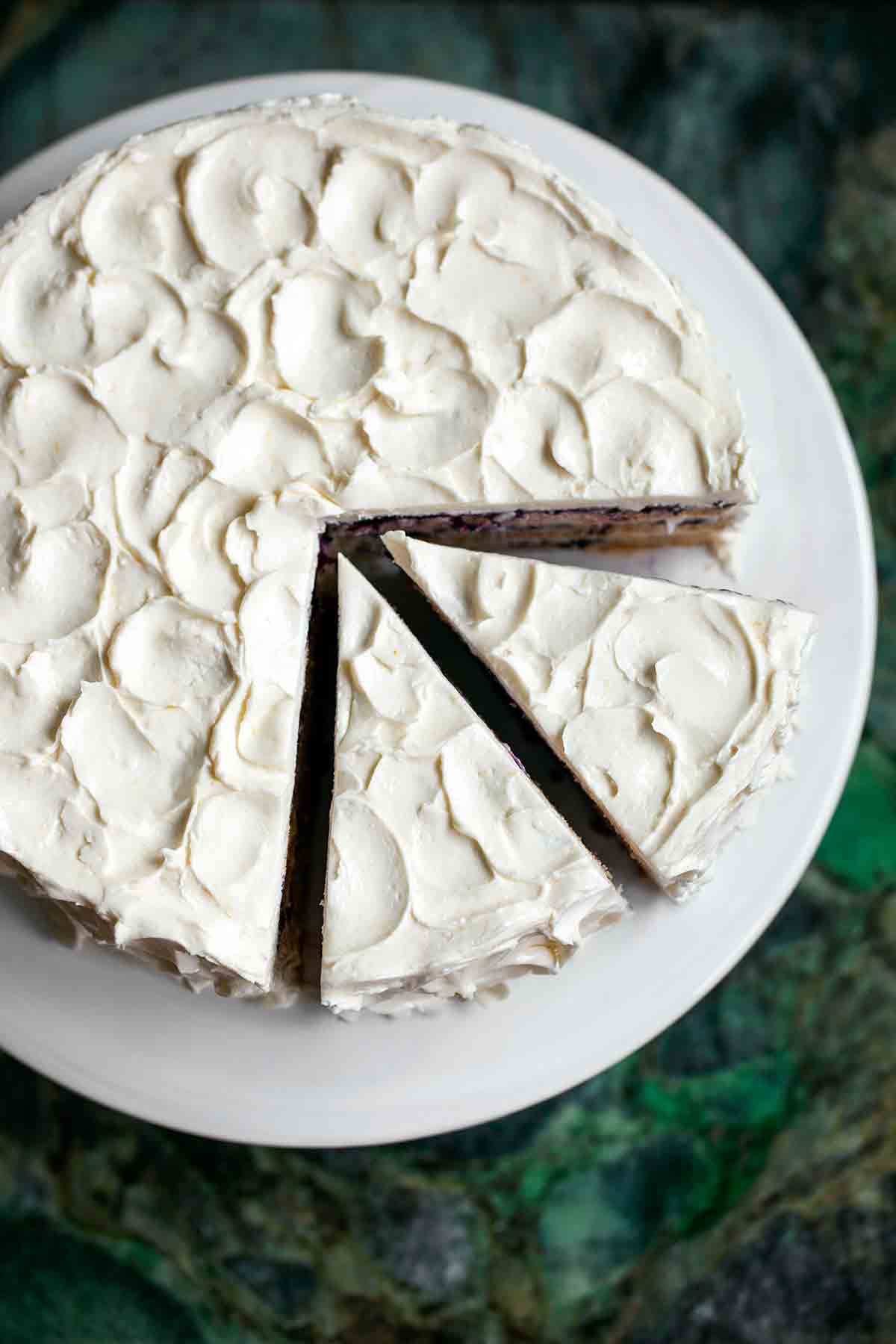 A blueberry-lemon layer cake on a white platter