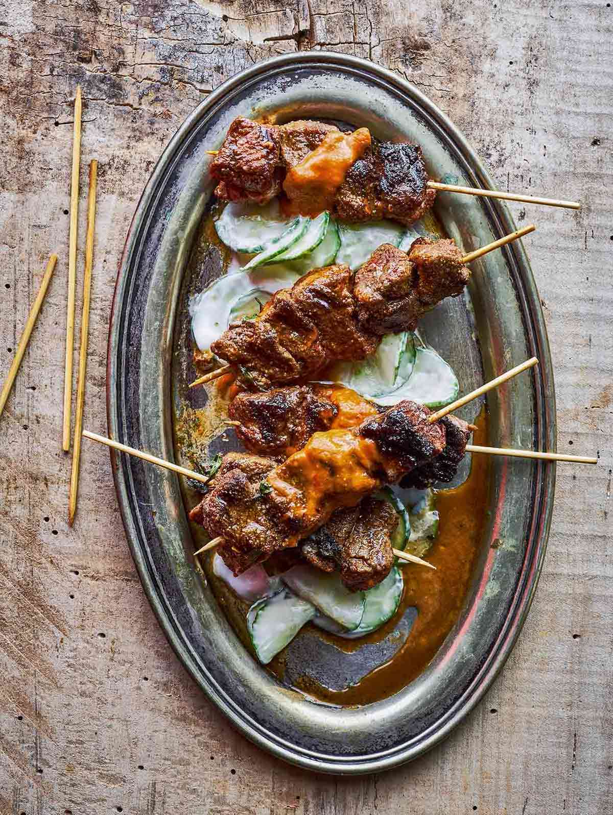 Catalan lamb skewers on sliced cucumbers topped with a romesco sauce