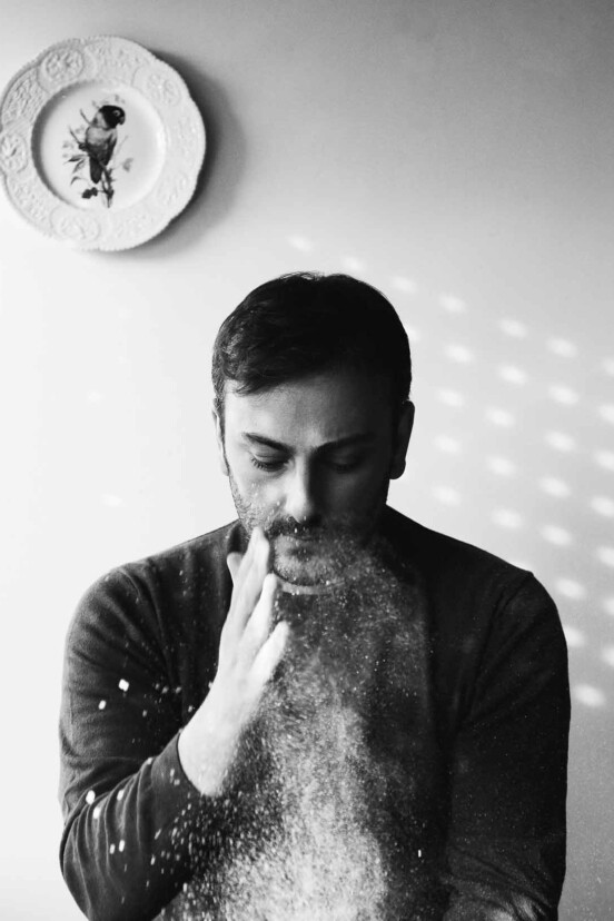 An image of Cenk Sönmezsoy dusting flour onto something.
