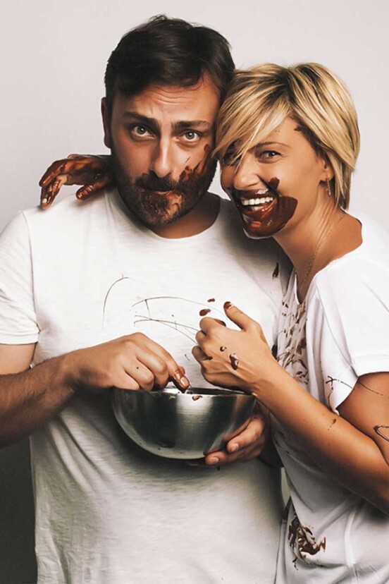 Cenk and a woman with their faces covered in chocolate.