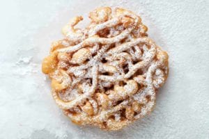 A mini funnel cake dusted with confectioners' sugar.