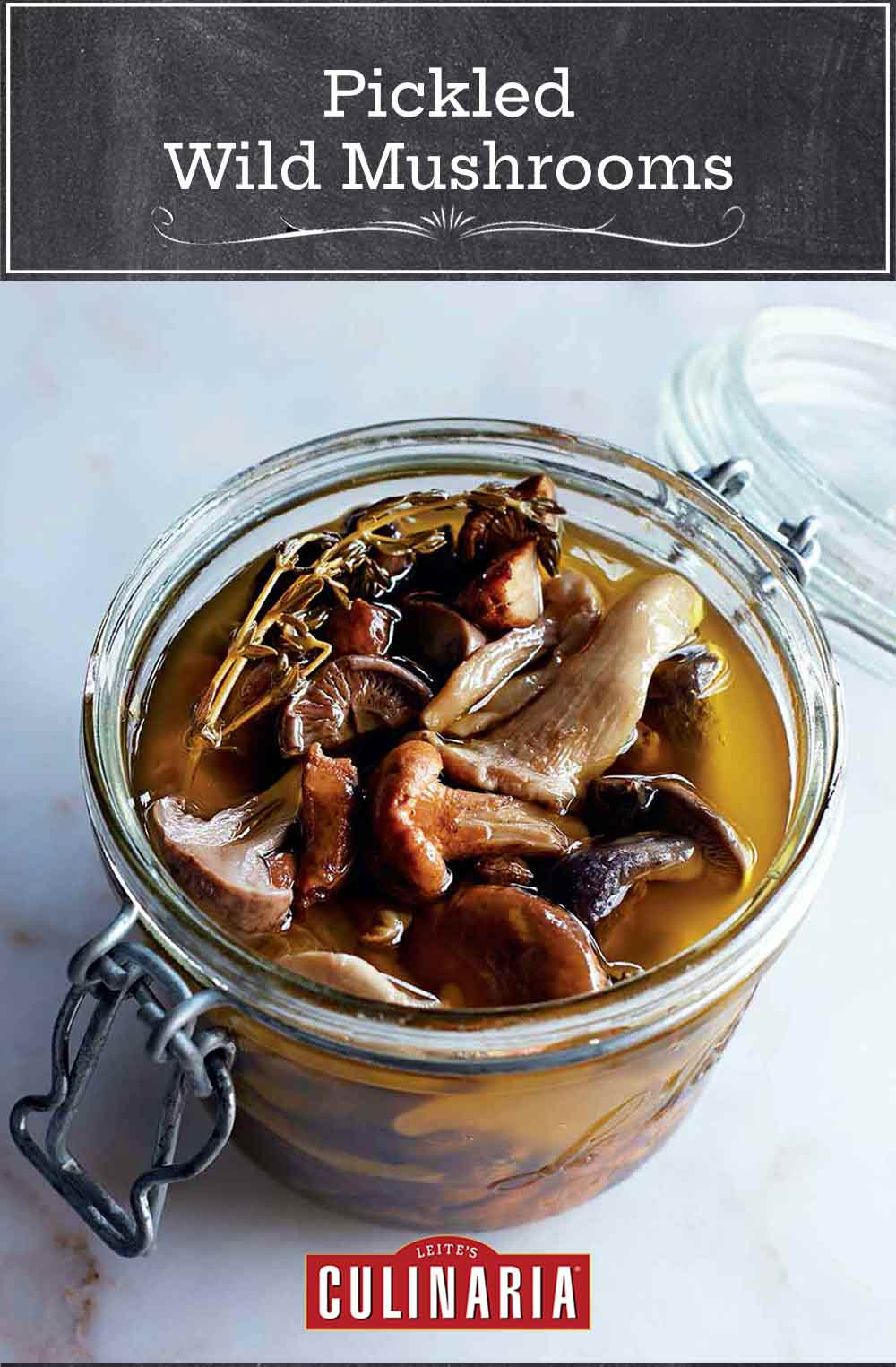 A canning jar filled with pickled wild mushrooms and a sprig of thyme.