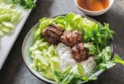 A dish filled with Vietnamese grilled pork patties with rice noodles and an crunchy vegetables.