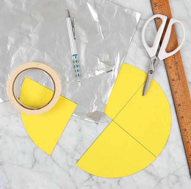 Quartered paper, foil, scissors, tape, and a ruler for making waffle cone shapers.