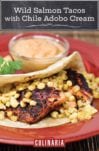 A wild salmon taco with roasted corn and chile adobo cream on the side on a red plate.