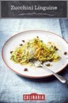 A white plate of zucchini linguine--with pasta, zucchini, garlic, capers, mint, dill, and cheese with a fork