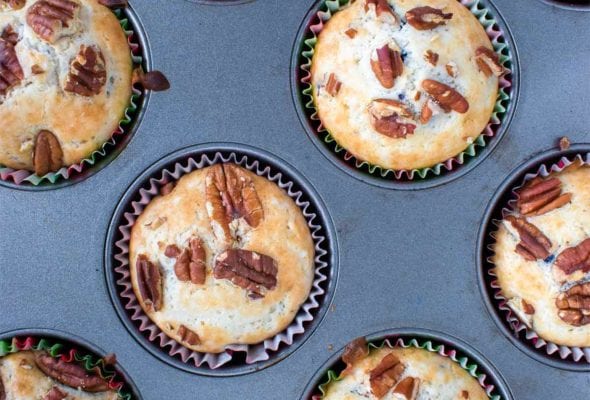Baked blueberry pecan muffins in a muffin tin.