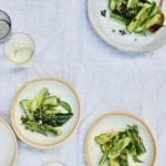 A serving plate and several individual plates topped with Chinese smashed cucumber salad.