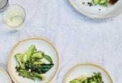 A serving plate and several individual plates topped with Chinese smashed cucumber salad.