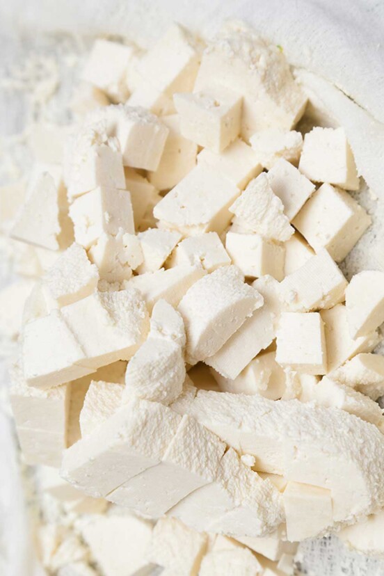 Cubes of fresh homemade paneer in a white cloth.