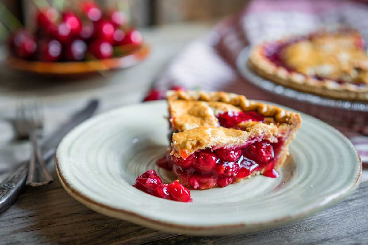A slice of cherry pie on a plate.