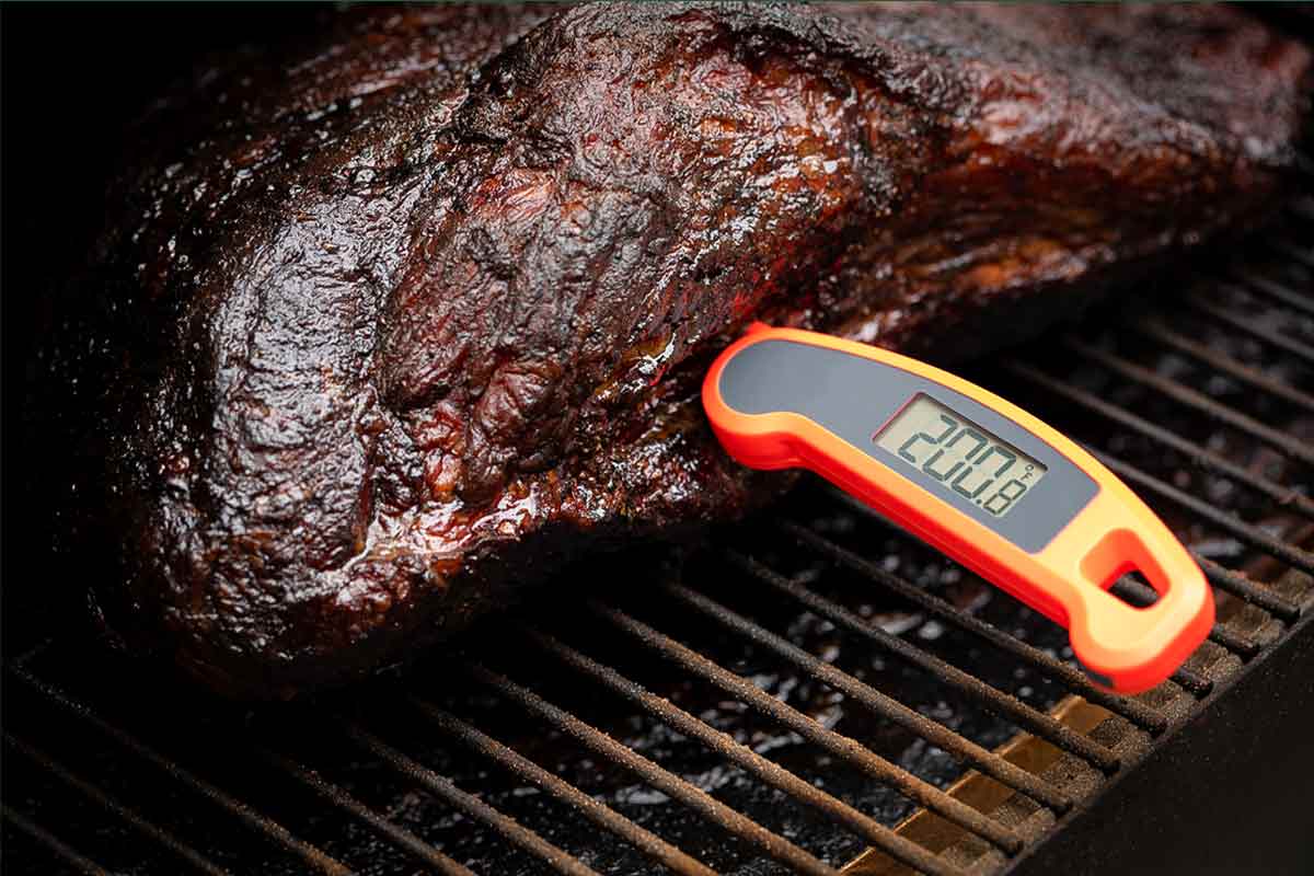 A thermometer inserted into a grilled piece of meat.