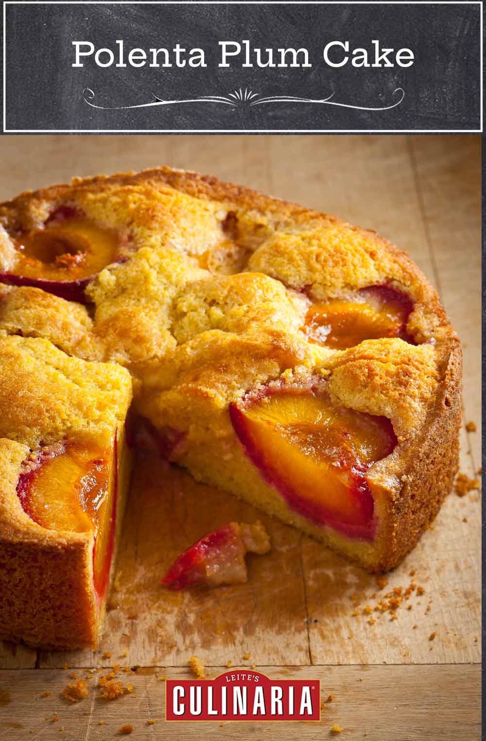 A round polenta plum cake on a wooden table with one slice cut from it.