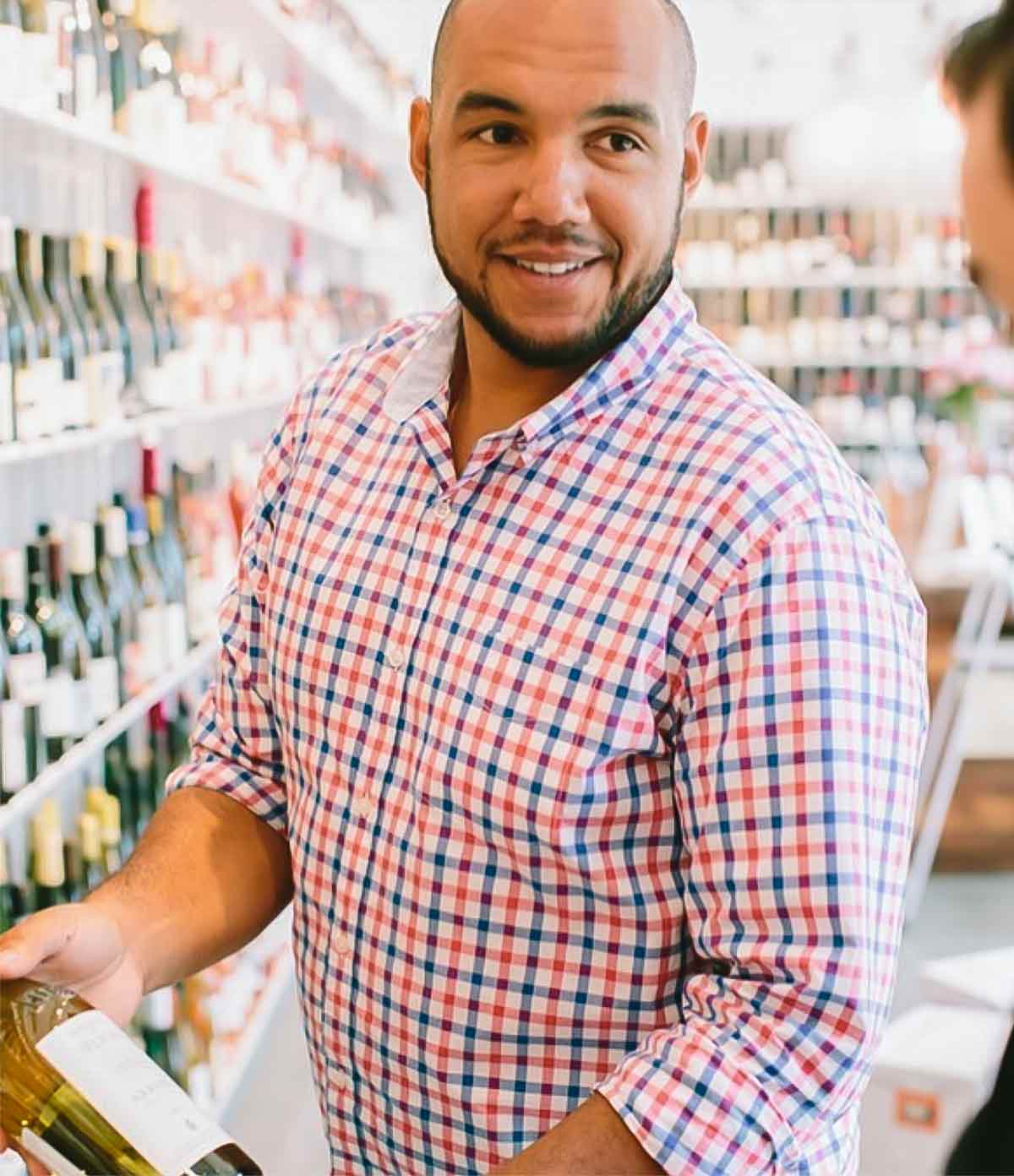 TJ Douglas showing a bottle of wine to a customer.