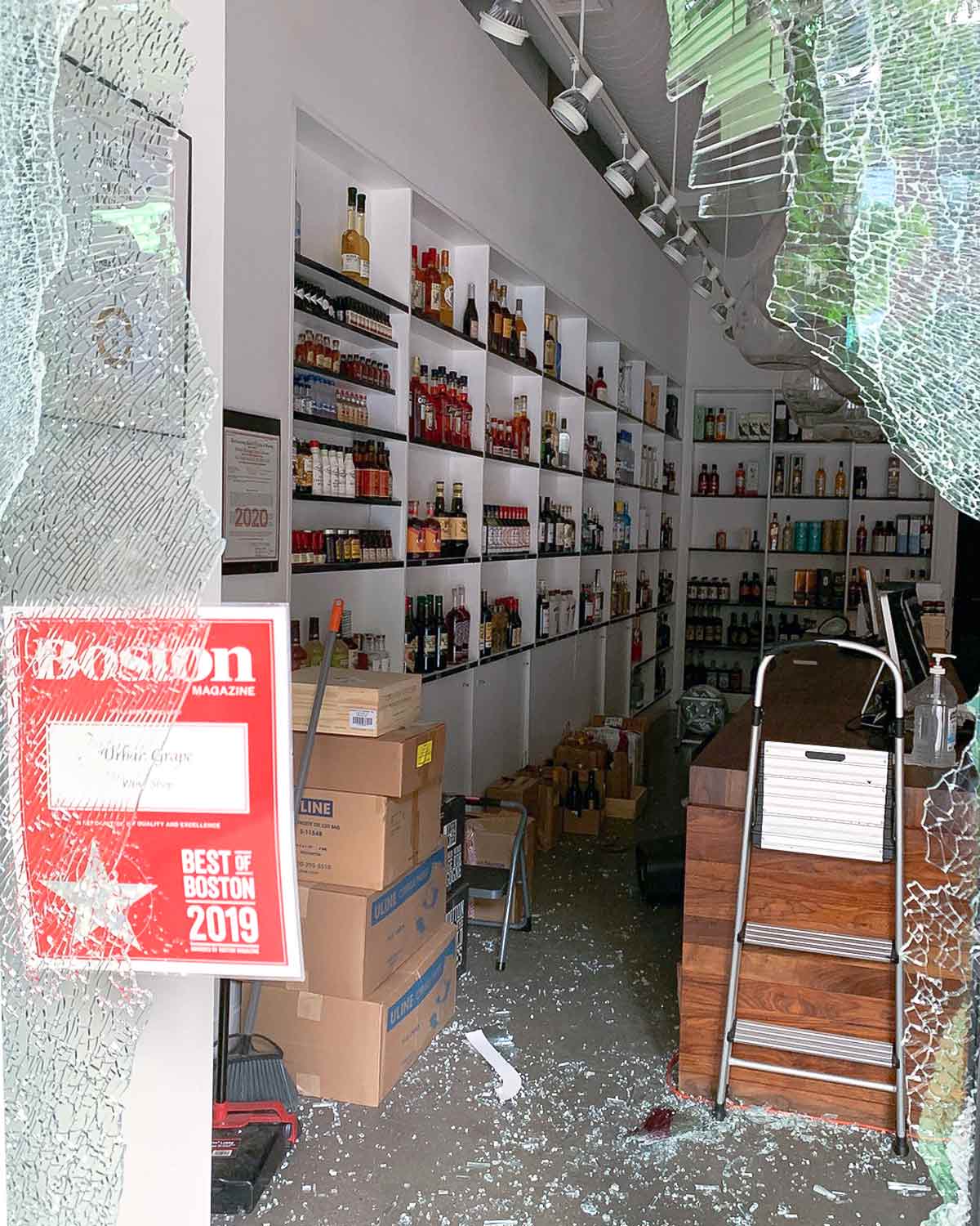 A local Boston store with a broken glass entry.