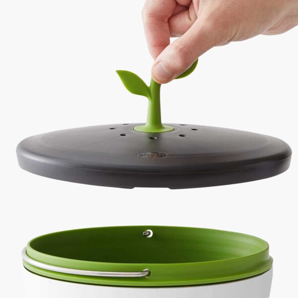 EcoCrock Counter Compost Bin with person holding top up.