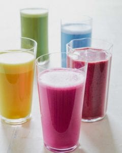 Four glasses of different flavored almond milk.