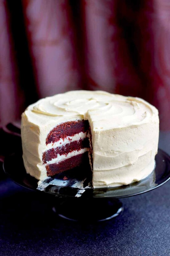 A red velvet cake with cream cheese frosting on a cake stand