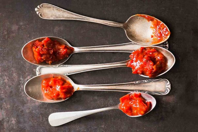 Five spoons each topped with a dollop of sambal oelek.