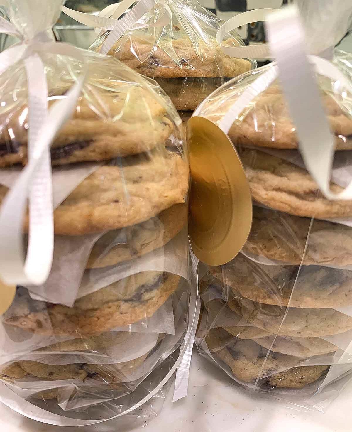 Three bags of soft chocolate chip cookies stacked on top of each other and tied with a white ribbon.