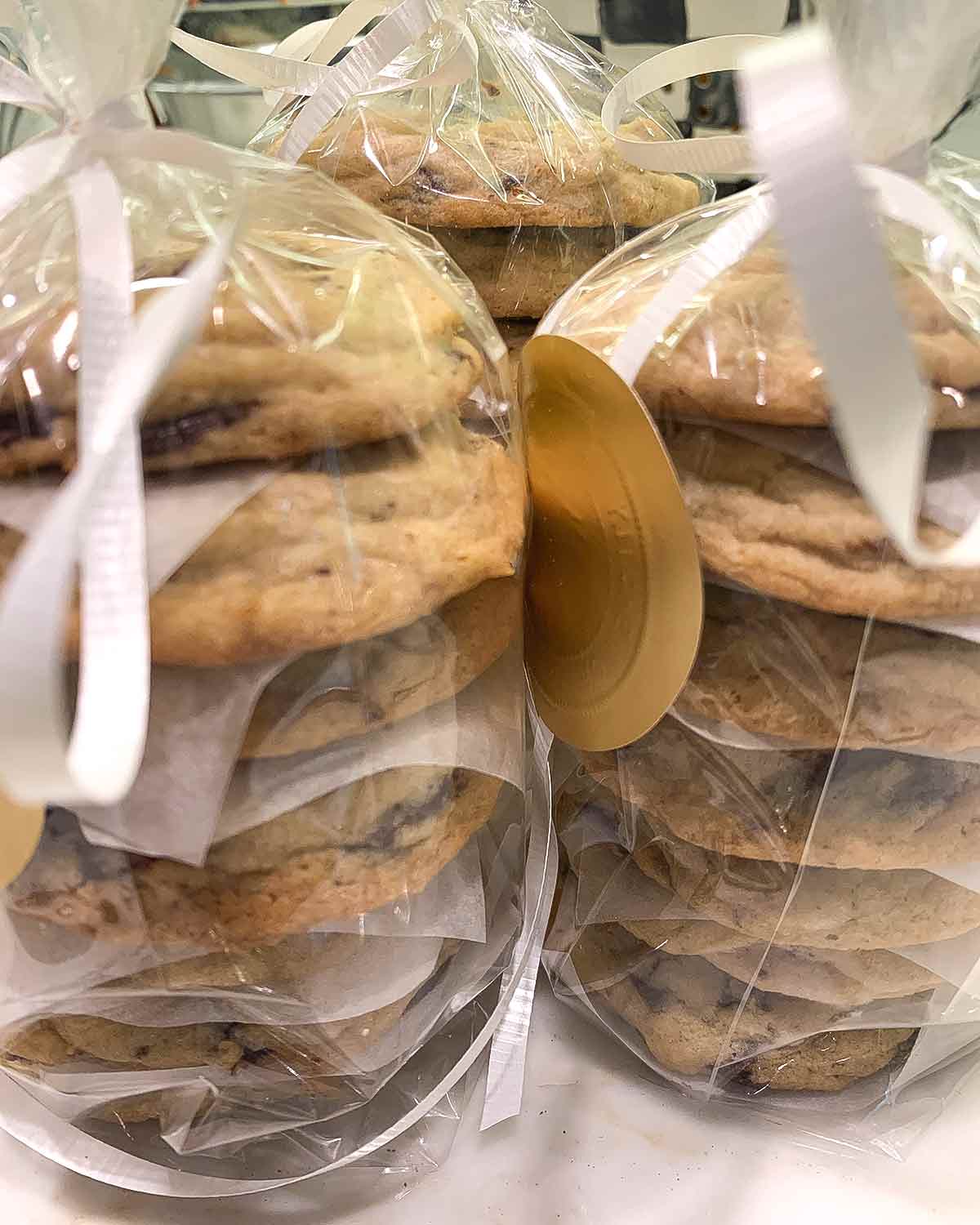 Three bags of soft chocolate chip cookies stacked on top of each other and tied with a white ribbon.