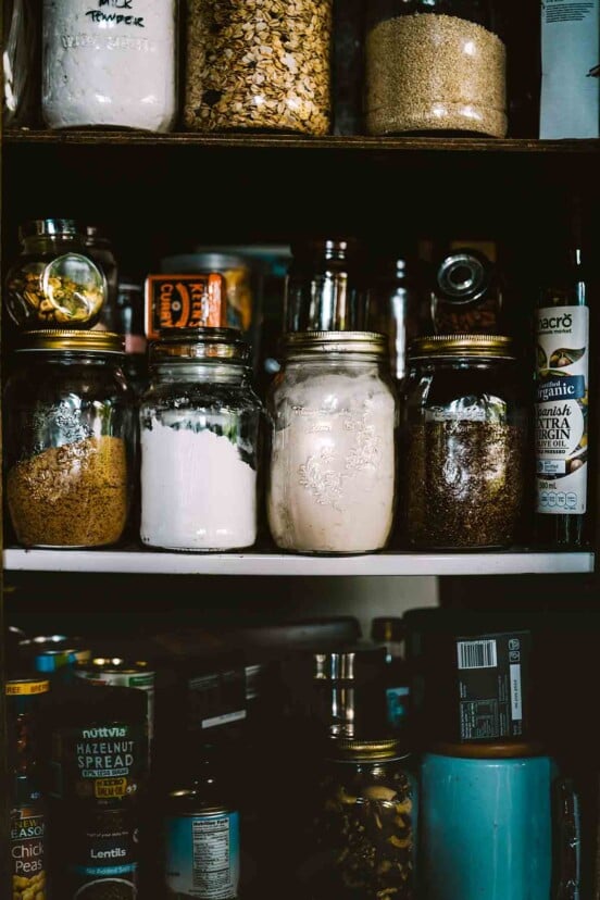 A pantry filled with jars of flour, grains, and spreads to illustrate that stockpiling of food is back.