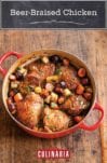 A red Dutch oven filled with beer-braised chicken with root vegetables on a wooden surface.
