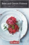 Two beet and carrot fritters, garnished with dill, on a white plate with a fork and a dollop of dill yogurt