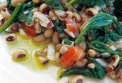 Black-eyed peas, spinach, red onion, and red pepper on a white plate.