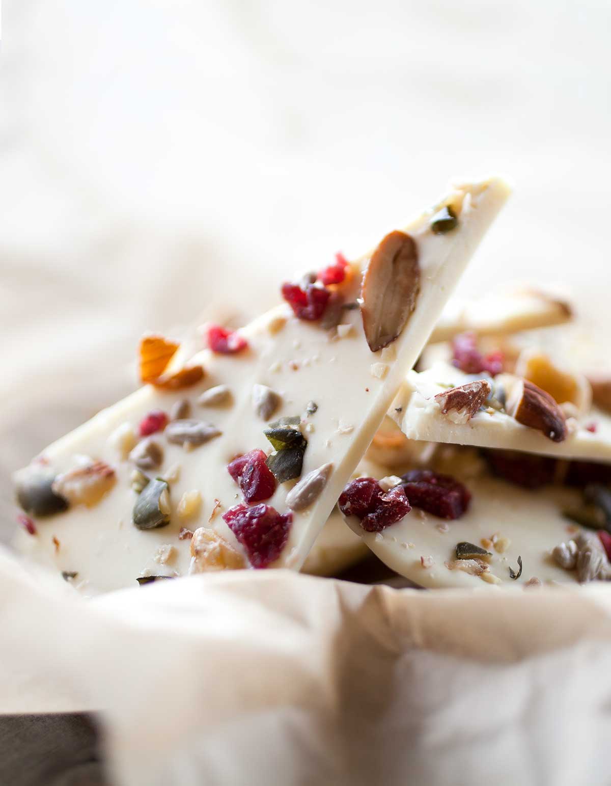 Several pieces of chocolate bark with apricots and pistachios in a basket