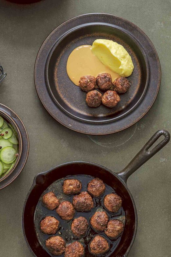 A cast-iron skillet filled with easy skillet meatballs, and a plate of meatballs with some sauce and mashed potatoes