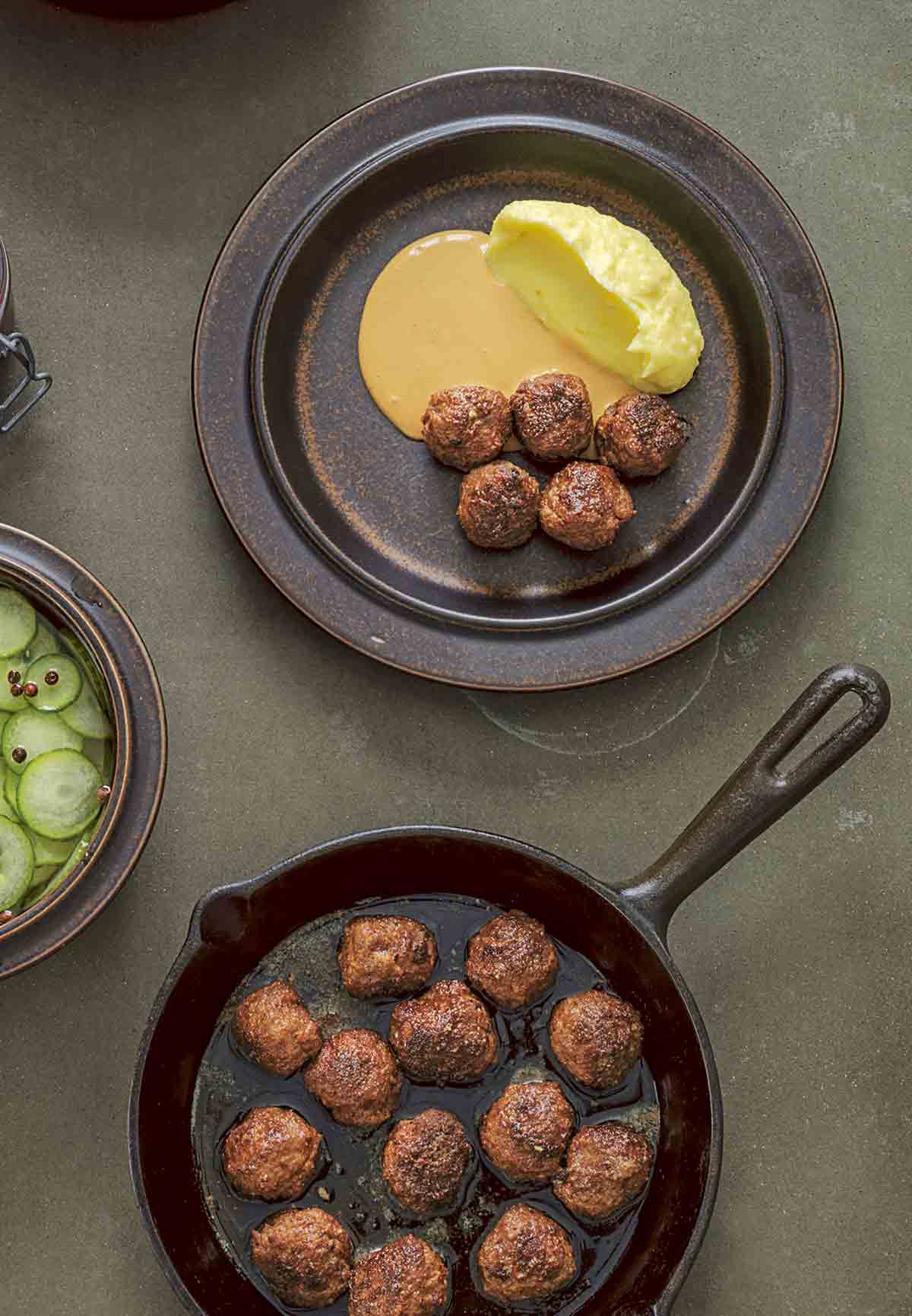 A cast-iron skillet filled with easy skillet meatballs, and a plate of meatballs with some sauce and mashed potatoes