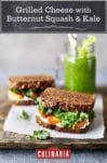 Two grilled cheese with caramelized butternut squash and kale on a pice of white paper with a green smoothie in the background.