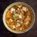 A ceramic bowl filled with hot and sour soup.
