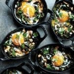 Mini Staub skillets filed with kale shakshuka--eggs, kale, and spices