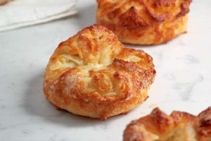Three koiugn amman--puff pastry coated with sugar--on white marble