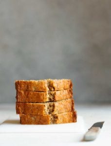 Slices of glazed nutmeg pound cake on a white cutting board