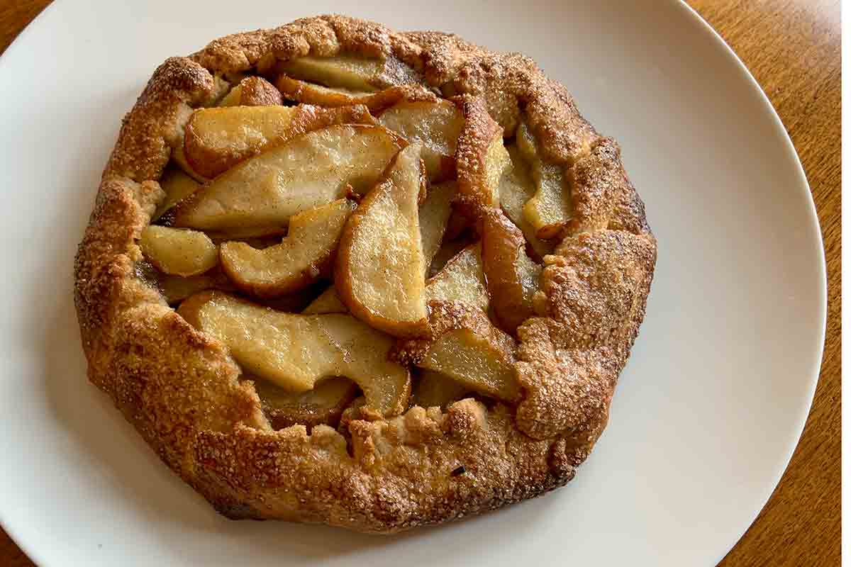 A baked pear galette on a white plate.