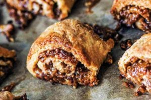 A dozen golden brown pecan pie rugelach with filling oozing out